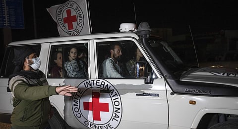 A Red Cross vehicle carrying Israeli hostages drives by at the Gaza Strip crossing into Egypt in Rafah on Saturday, Nov. 25, 2023. (AP Photo)