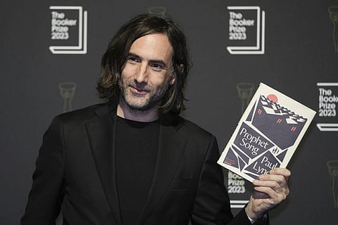 Irish author Paul Lynch poses with his book 'Prophet Song' during a photocall with the six shortlisted authors for the Booker Prize 2023, in London, Thursday, Nov 23, 2023. (Photo | AP)