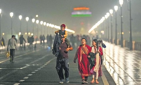 Pedestrians enjoy a stroll at Kartavya Path amid drizzle on Monday. (Photo | PTI)