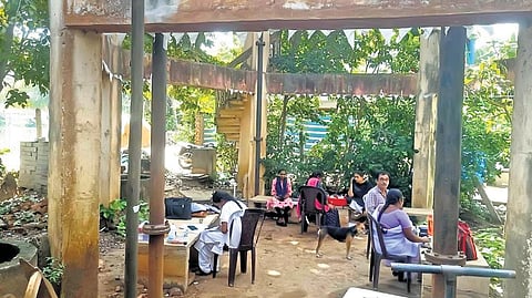 Hospital staff seen working under an overhead tank at the PHC in Pallamkurru village in Konaseema district.