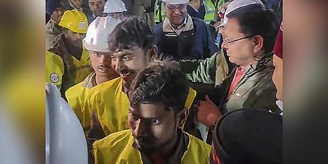 Uttarakhand Chief Minister Pushkar Singh Dhami and Union Minister of State for Road Transport & Highways VK Singh greet rescued workers coming out of the collapsed Silkyara Tunnel. (Photo | PTI)