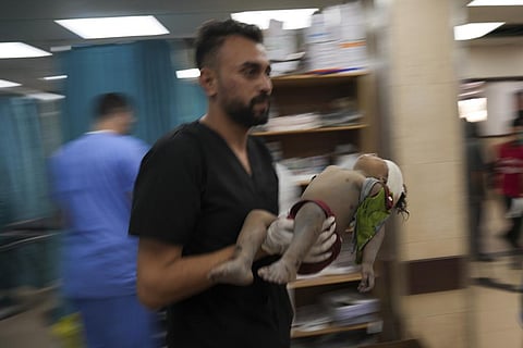 Palestinian child wounded in Israeli bombardment is brought to a hospital in Deir al Balah, south of the Gaza Strip. (Photo | AP)