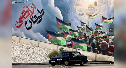 A car drives past a giant poster depicting the Hamas called 'Operation Al-Aqsa Flood' in the Lebanese capital Beirut on November 2, 2023 | AFP