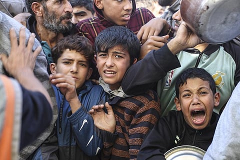 Palestinian children line up for food in Rafah, Gaza Strip during a temporary ceasefire between Israel and Hamas in November last year.