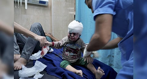 Palestinian child wounded in Israeli bombardment is treated in a hospital in Deir al Balah. (Photo | AP)