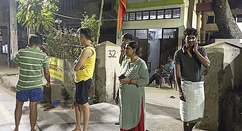 People gather outside their offices after tremors were felt due to an earthquake, in Patna. (Photo | PTI)