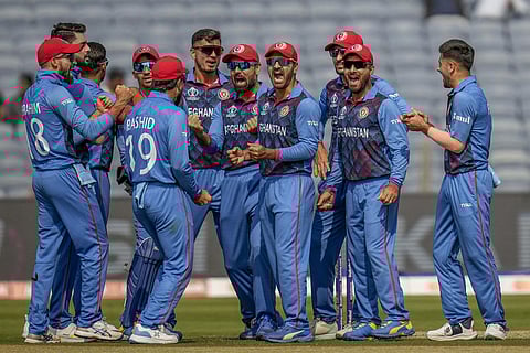 Afghanistan players celebrate the dismissal of Sri Lanka's Dimuth Karunaratne during the ICC Men's Cricket World Cup match between Sri Lanka and Afghanistan in Pune. (File photo | AP)