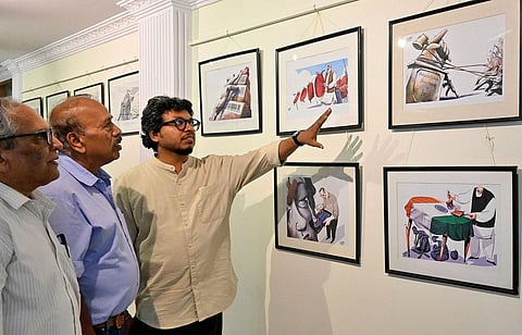 Cartoonist BG Gujjarappa takes a look at the cartoons of Soumyadip Sinha at the Indian Cartoon Gallery in Bengaluru. (Photo | Shashidhar Byrappa)