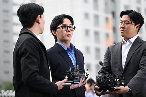K-pop star G-Dragon (C) speaks to the media as he arrives at a police station for his police questioning in Incheon on November 6. (Photo | AFP)
