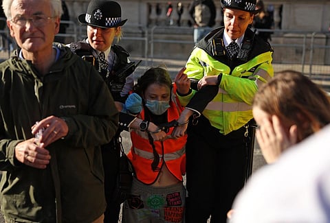 A Just Stop Oil climate activist is arrested by Metropolitan Police officers after taking part in a slow march to disrupt traffic, on Whitehall in London on November 6. (Photo | AFP)