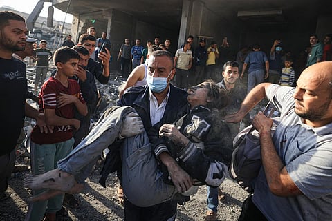 Palestinians carry a victim of Israeli bombardment in Khan Yunis in the southern Gaza Strip. (Photo | AFP)