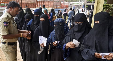 Voters get their identification cards checked as they arrive to cast their votes for the Telangana Assembly elections, in Hyderabad.