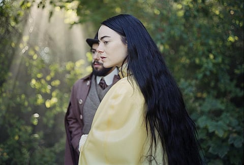 Ramy Youssef, background, and Emma Stone in a scene from 'Poor Things.' | AP