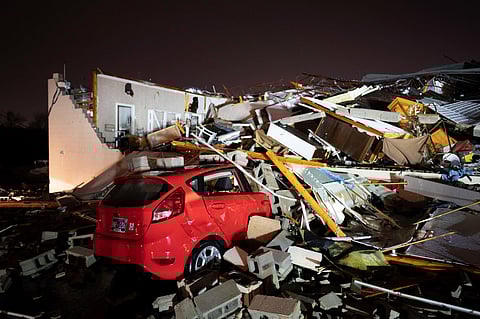 A car is buried under rubble on Main Street after a tornado hit Hendersonville on Saturday | AP