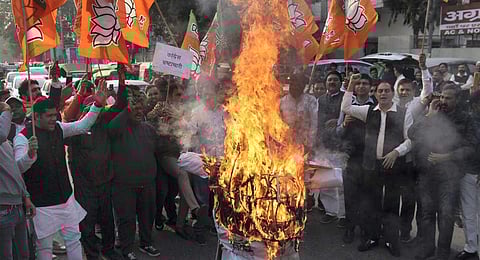 BJP leaders and supporters burn an effigy during a protest against Congress MP Dheeraj Sahu over the corruption allegations against him, in Gurugram, Sunday, Dec. 10, 2023. (PTI)