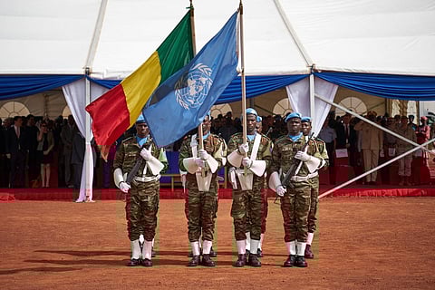 FILE -Â Soldiers hold the UN and Malian flags during the ceremony of Peacekeepers' Day at the operating base of MINUSMAÂ in Bamako on May 29, 2018. (Photo | AFP)