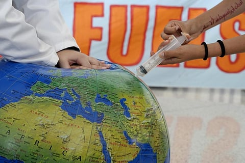 Activists pretend to resuscitate the Earth during a demonstration at the COP28 UN Climate Summit in Dubai (File Photo | AP)