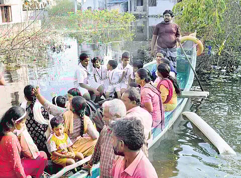Schools have reopened after cyclone Michaung, students are returning home by boat at flooded Yamuna Nagar in Nazarathpet. (Photo | Martin Louis, EPS)