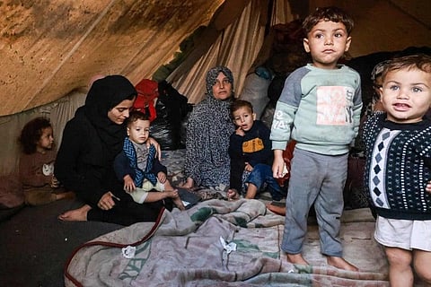 Palestinians rest in their makeshift tent at a camp set up on a schoolyard in Rafah in the southern Gaza Strip where most civilians have taken refuge. (Photo | AFP)