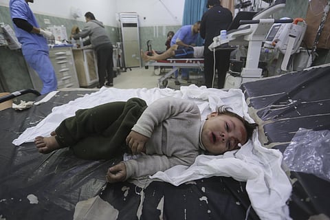 A Palestinian child wounded in the Israeli bombardment of the Gaza Strip is brought to a hospital in Rafah. (Photo | AP)