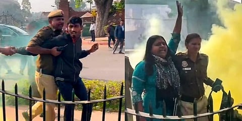 Police personnel apprehend two persons carrying a can emitting yellowish smoke outside the Parliament premises, during the Winter session, in New Delhi (Photo | PTI)