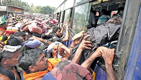 Pilgrims at Nilakkal rush to catch the bus to Pampa on Tuesday | SHAJI VETTIPURAM