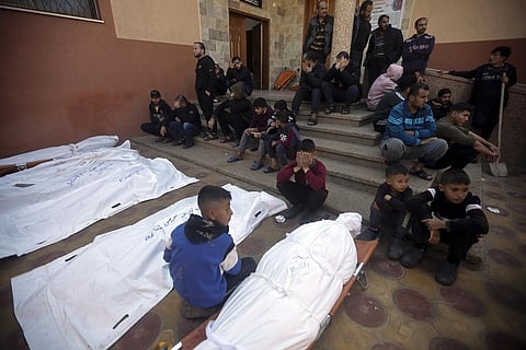 Palestinians mourn relatives killed in the Israeli bombardment of the Gaza Strip outside a morgue in Khan Younis on Friday, Dec. 15, 2023. (AP Photo)