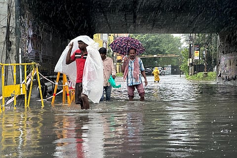 FILE: People walk through inundated roads in Nolambur, following the aftermath of cyclone Michuang in Chennai, on Monday. (Photo | Sunish P Surendran, EPS)