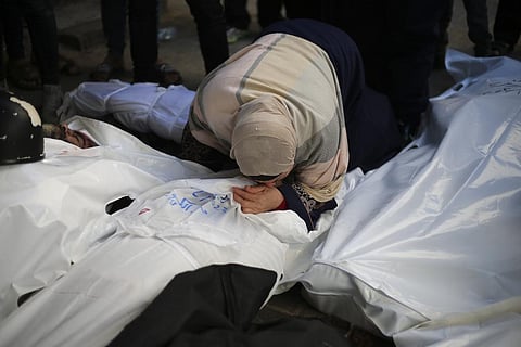 Palestinians mourn relatives killed in the Israeli bombardment of the Gaza Strip outside a morgue in Rafah. (Photo | AP)