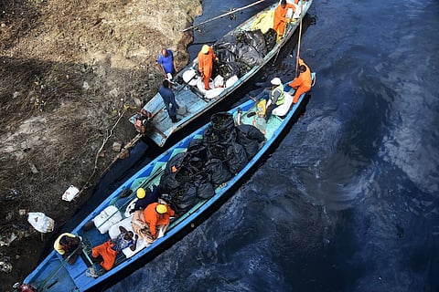CPCL oil recovery team seen removing the water hyacinth plant and dumping it up in a plastic bag at oil filled Buckingham canal at Ennore in Chennai. (Photo | P. Ravikumar, EPS)