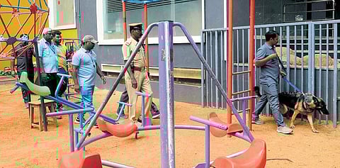 Bomb squad personnel and police scan a school following the bomb threat email in Bengaluru on Friday