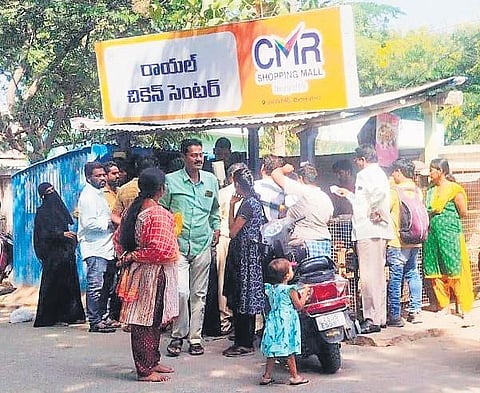 People gather at a chicken centre to redeem coupons in Miryalaguda on Friday