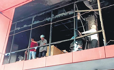 Workers are seen salvaging the charred remains of files from the Telangana tourism department head office, which was engulfed in a fire on Friday morning