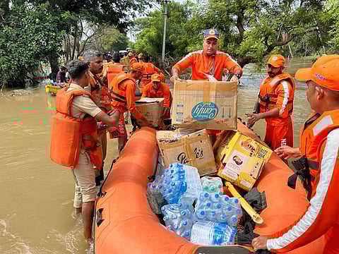 NDRF personnel distribute food and other essential materials to stranded people amid floods after heavy rainfall, in Thoothukudi | PTI