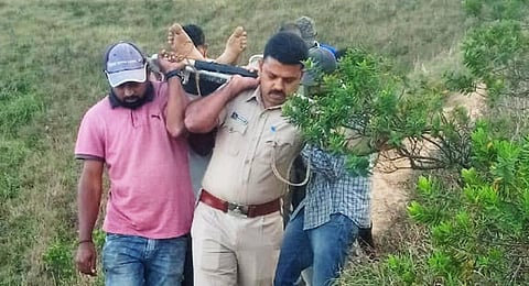 Forest officials and police carried the dead body of the victim from the peak. (Photo | Express)