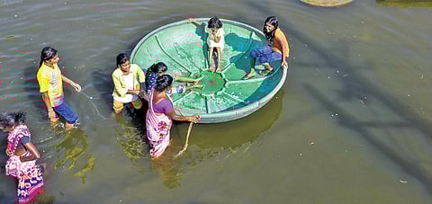 Children being ferried across stagnant water with help of coracle at Thiru VK Nagar in Thoothukudi | V KARTHIKALAGU
