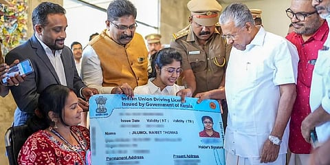 Jilumol Mariet Thomas receives her driving licence card from Chief Minister Pinarayi Vijayan in Palakkad on Saturday