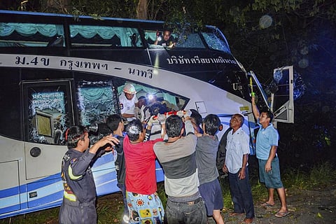 Rescue workers and volunteers rescue an injured passenger at the site of a bus accident Tuesday. (Photo | AP)