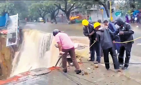 When the container truck with two men inside fell into the pit, the road around the pit and a small godown nearby also collapsed and fell inside | express