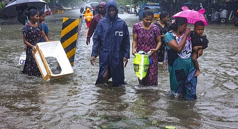eople wade through a waterlogged road during heavy rain owing to Cyclone Michaung, in Chennai. (Photo | PTI)
