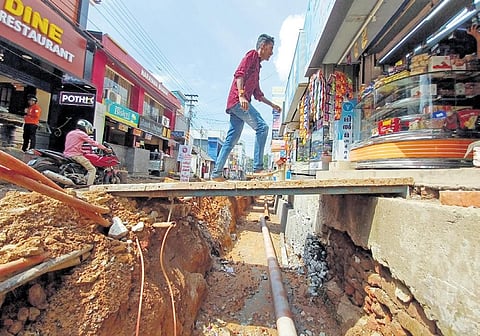 A man walks on a temporary ramp kept over the dug up Statue-General Hospital stretch in Thiruvananthapuram to enter a shop | B P Deepu