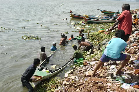 Fishermen trying to recover an overturned boat at Gollapudi near Vijayawada on Wednesday. (Prasant Madugula)