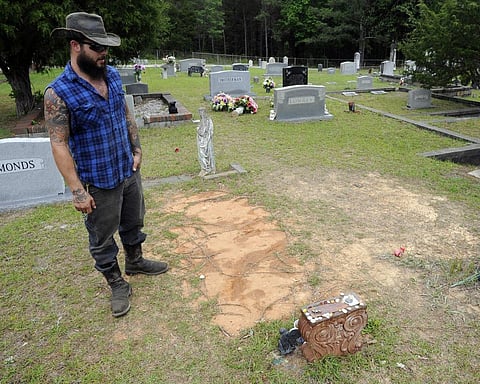 Tyler Goodson of the hit podcast 'S-Town' stands at the grave in Green Pond, Ala., of his late friend John B. McLemore, who is also featured in the show, on May 3, 2017. (AP)