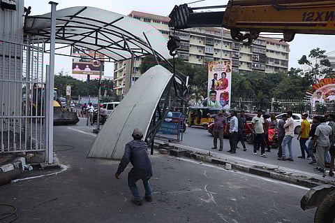 Workers seen removing a 20-foot-high iron fence and barricade on the road in front of the Pragathi Bhavan in Hyderabad. (Sri Loganathan Velmurugan)