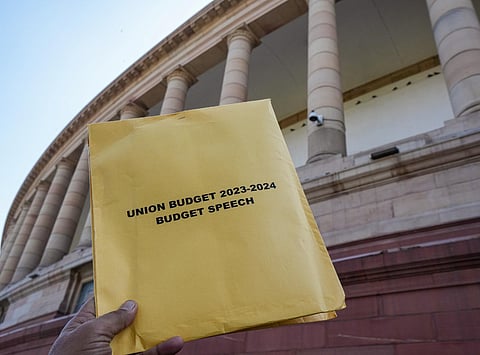 A copy of Union Budget 2023-24 in the backdrop of the Parliament House in New Delhi, Wednesday, Feb. 1, 2023. (Photo | PTI)
