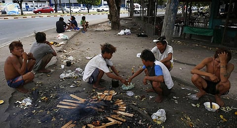 Yanomami Indigenous people eat food cooked on fire in Boa Vista, Roraima state, Brazil. (Photo | AP)