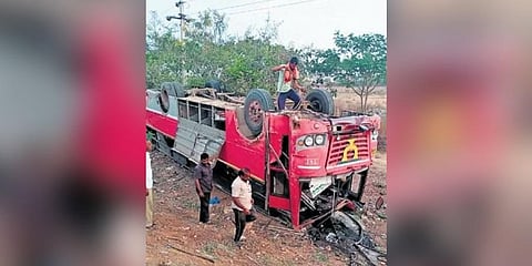 ​ A worker checks the Tirupathi-bound TSRTC bus from Hyderabad that overturned at Kothakota bypass road on NH 44 on Saturday night ​
