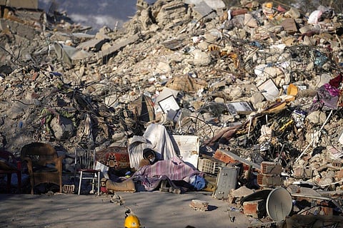 A man sleeps in front of a destroyed building in Kahramanmaras, southeastern Turkey, Monday, Feb. 13, 2023. (Photo | AP)