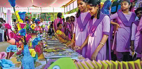 Government school students take a look at the handicrafts exhibited at a stall at the book festival in Vijayawada on Tuesday | Prasant Madugula