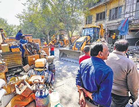 People look at the demolition of alleged illegal structure during an anti-encroachment drive by the DDA at Mehrauli in New Delhi. (File photo | PTI)